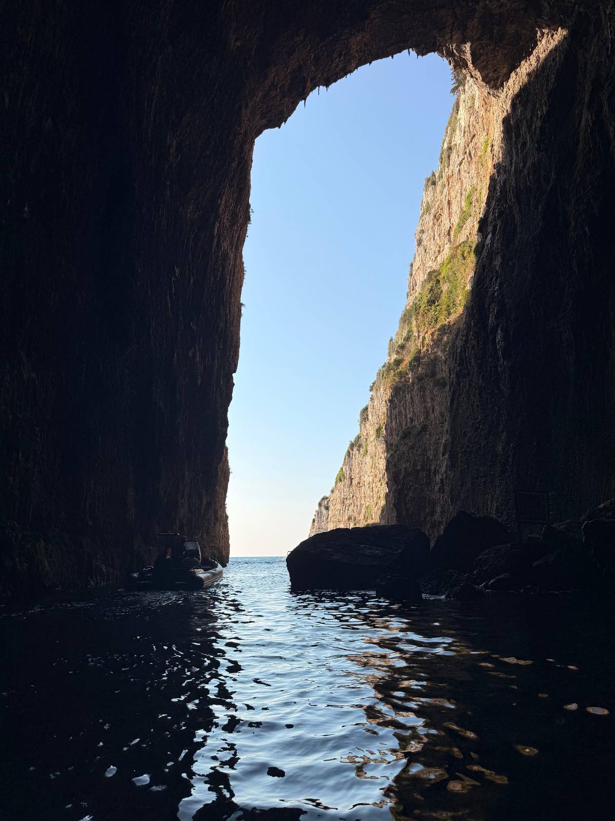 Looking out of a tall sea cave toward the open water