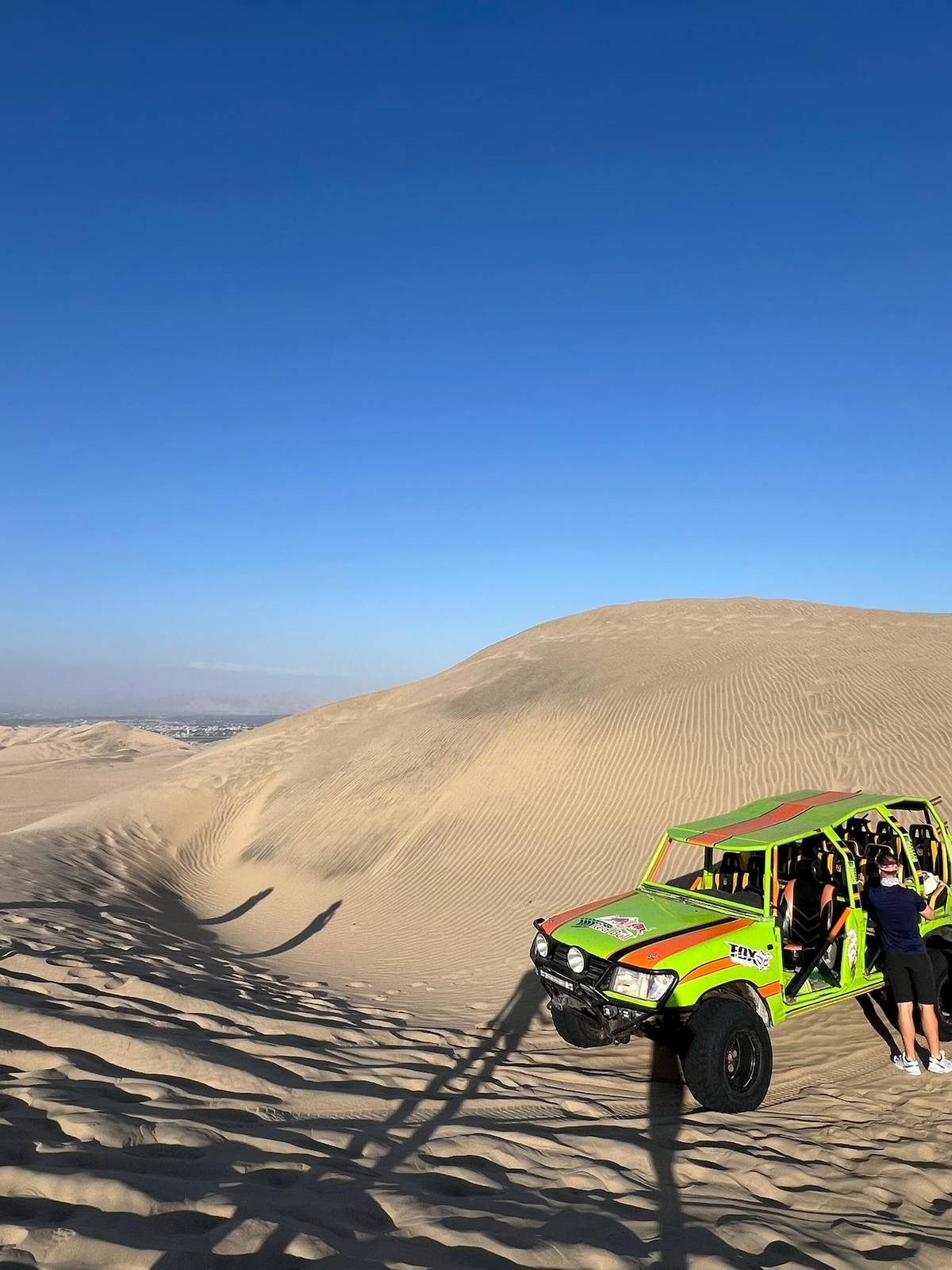 A dune buggy parked high on the sand
