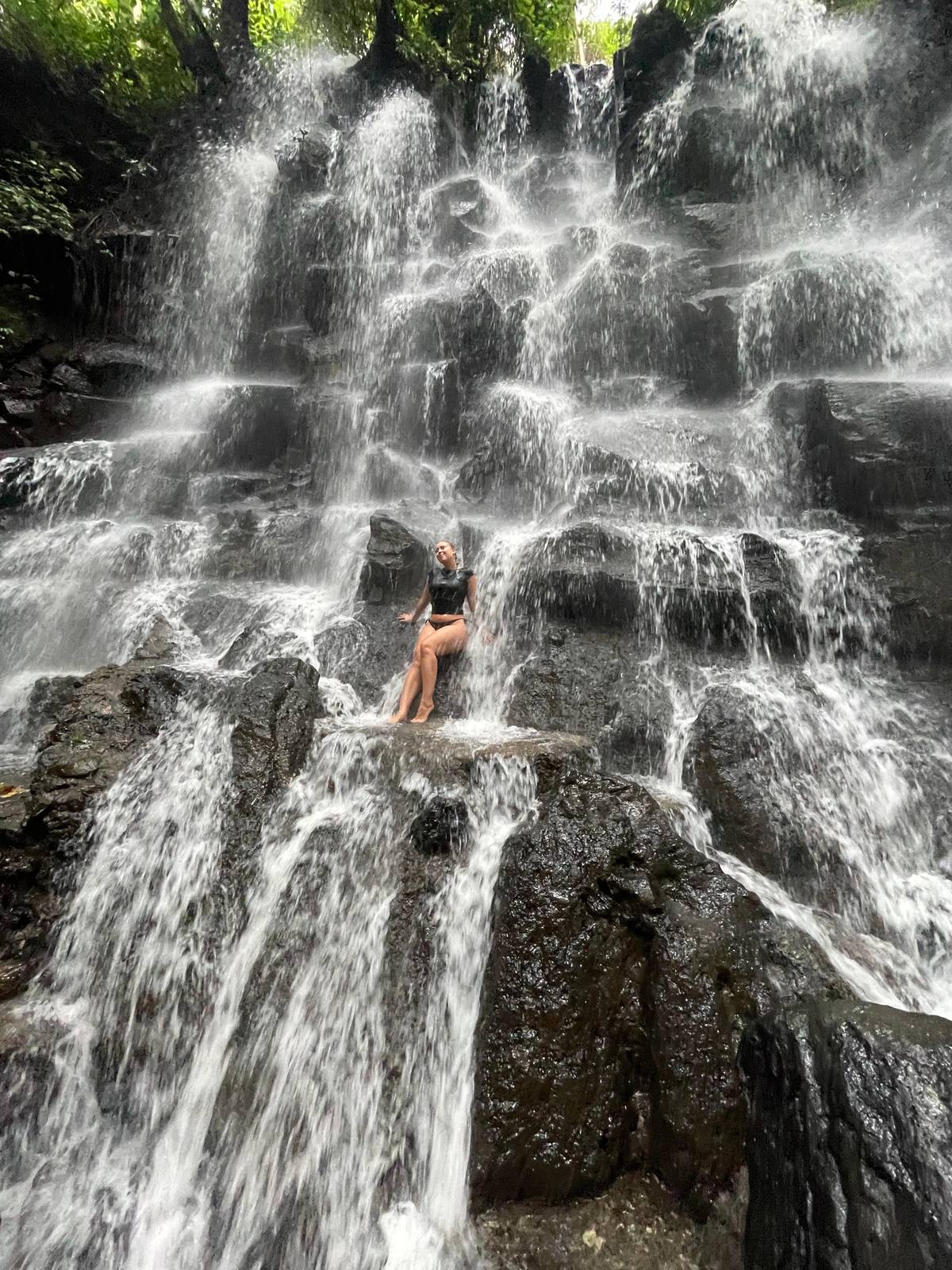 Water spilling over a wide staircase of dark rock