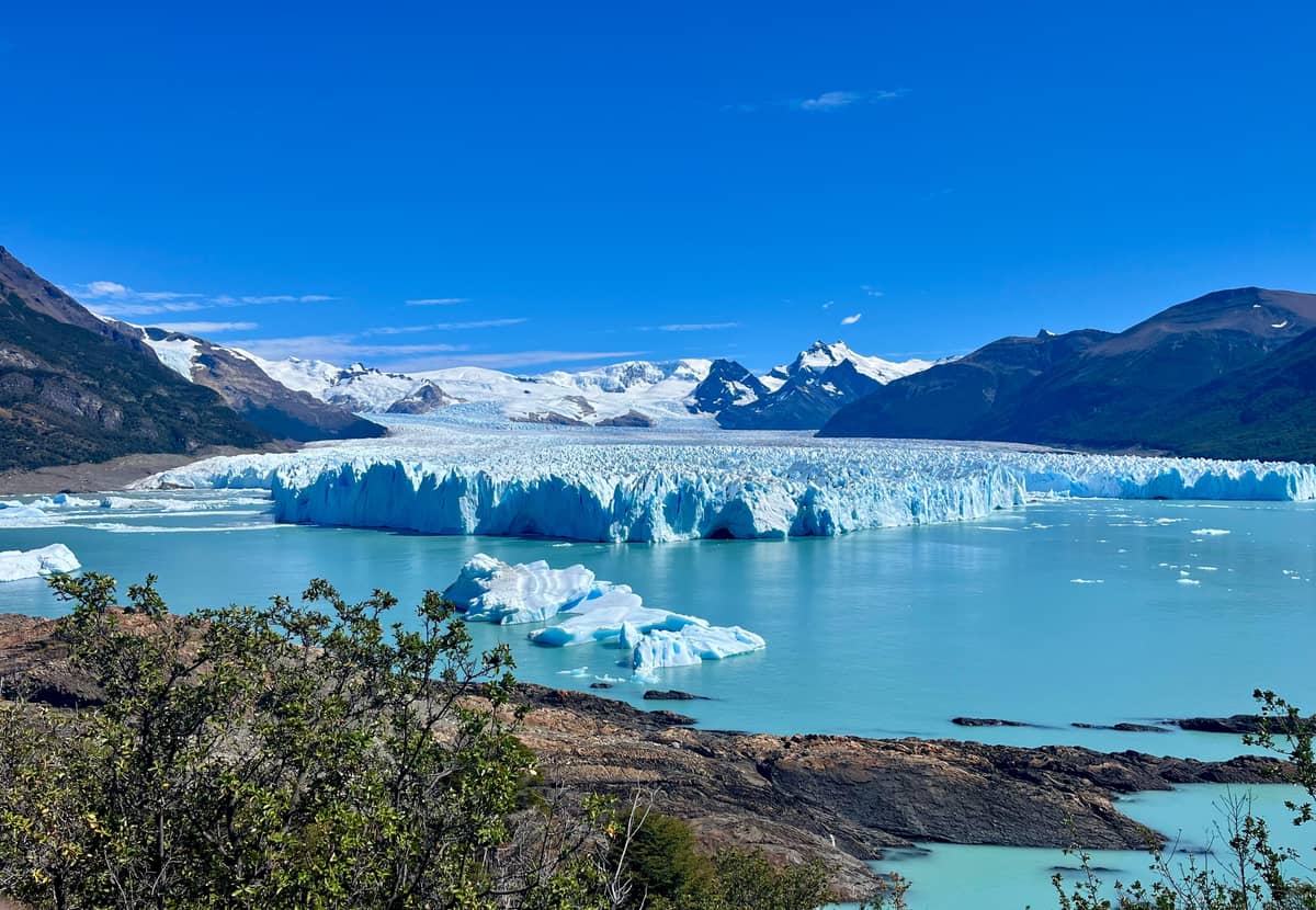 The glacier front and Lago Argentino under a blue sky