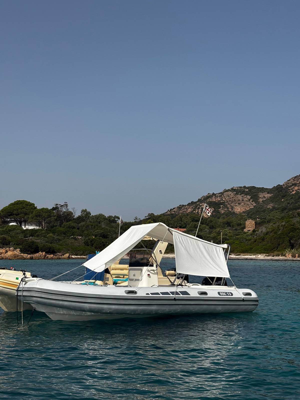 A boat with a sun awning at anchor