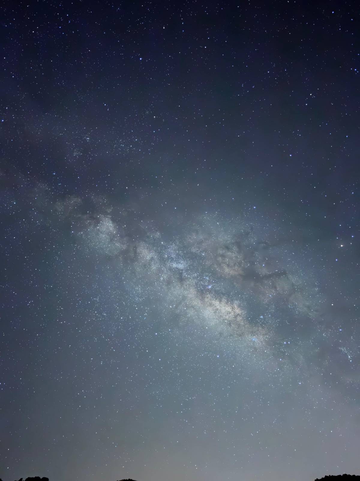 The Milky Way rising over a dark mountain ridge