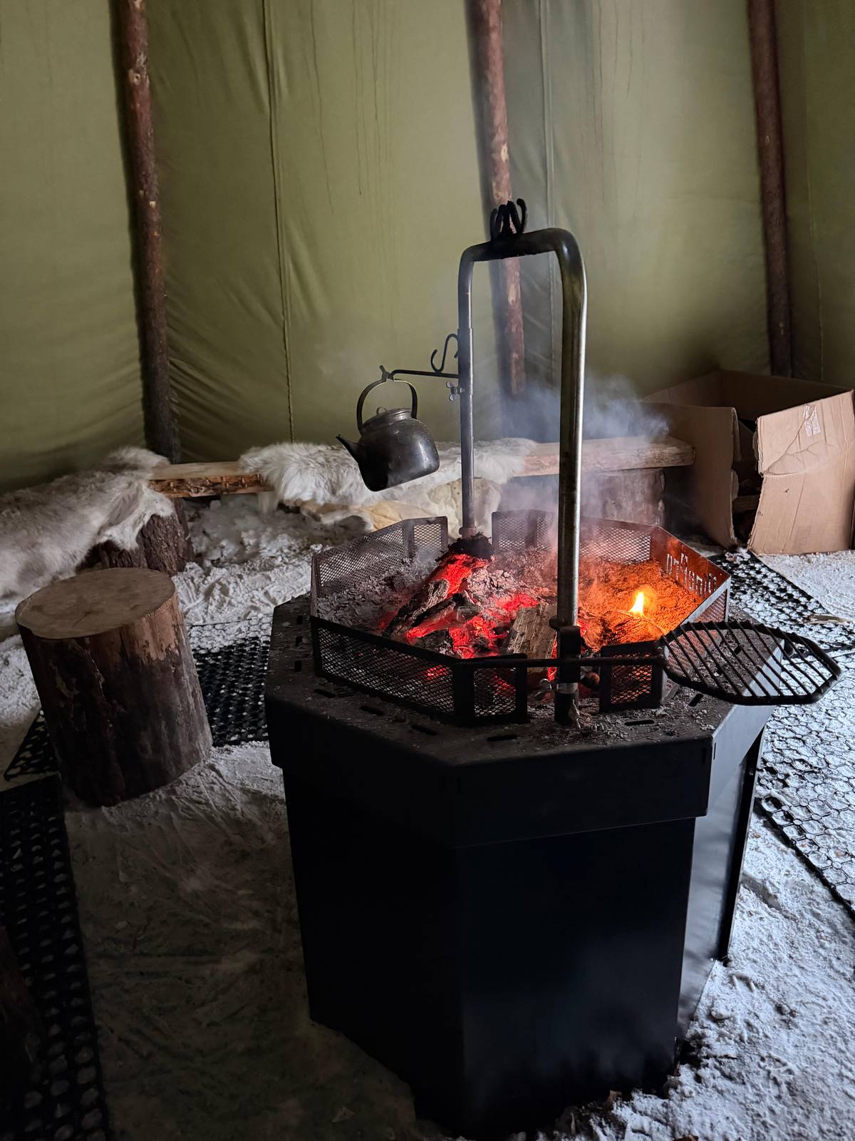 The fire inside the kota with a kettle above it