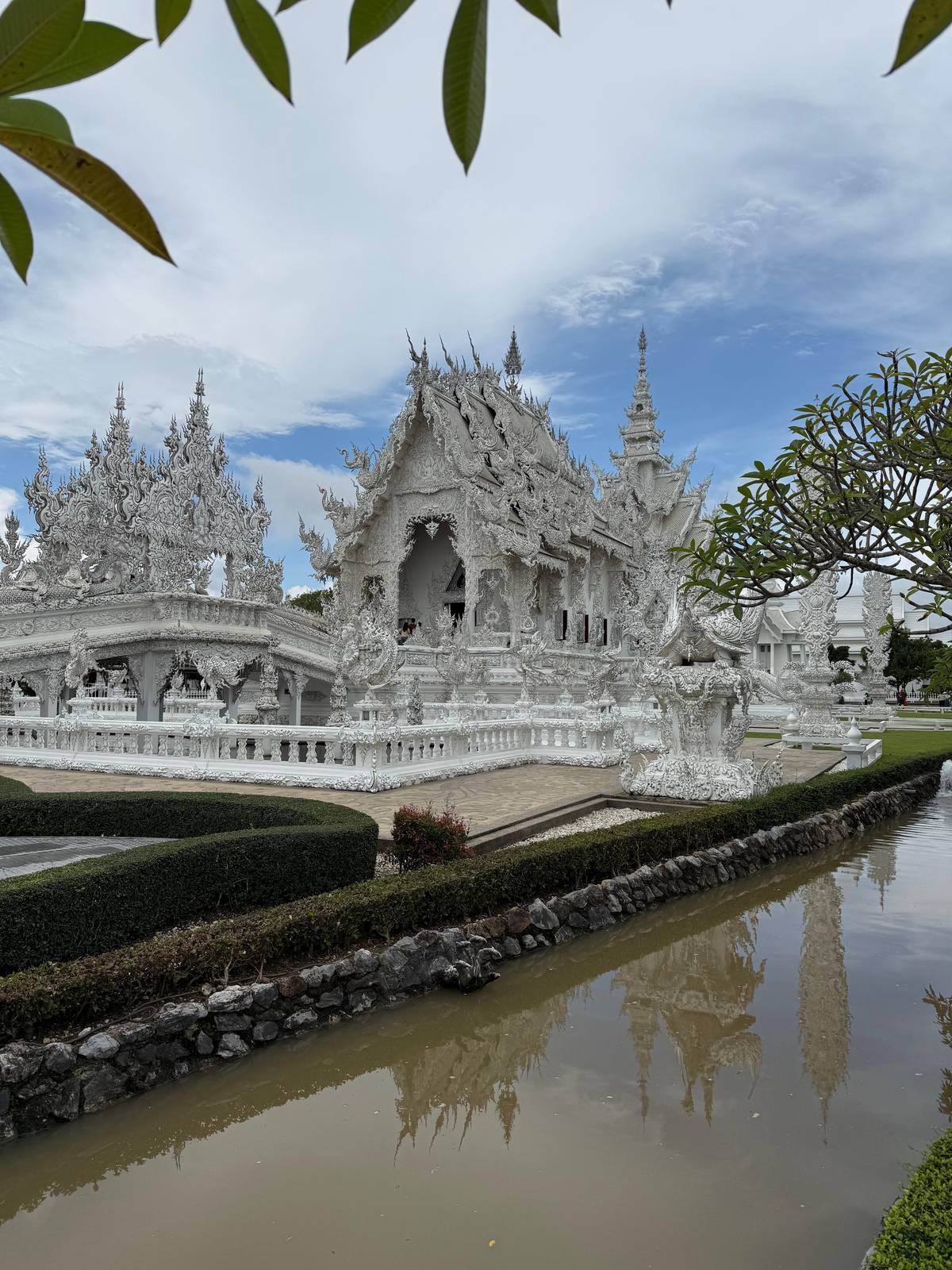 The White Temple behind its pond under a blue sky