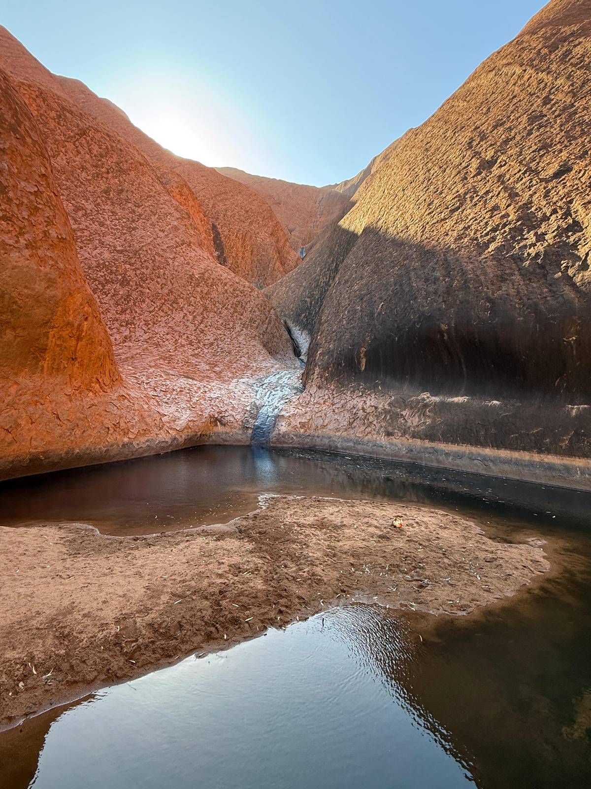 Still water reflecting the rock walls at the waterhole