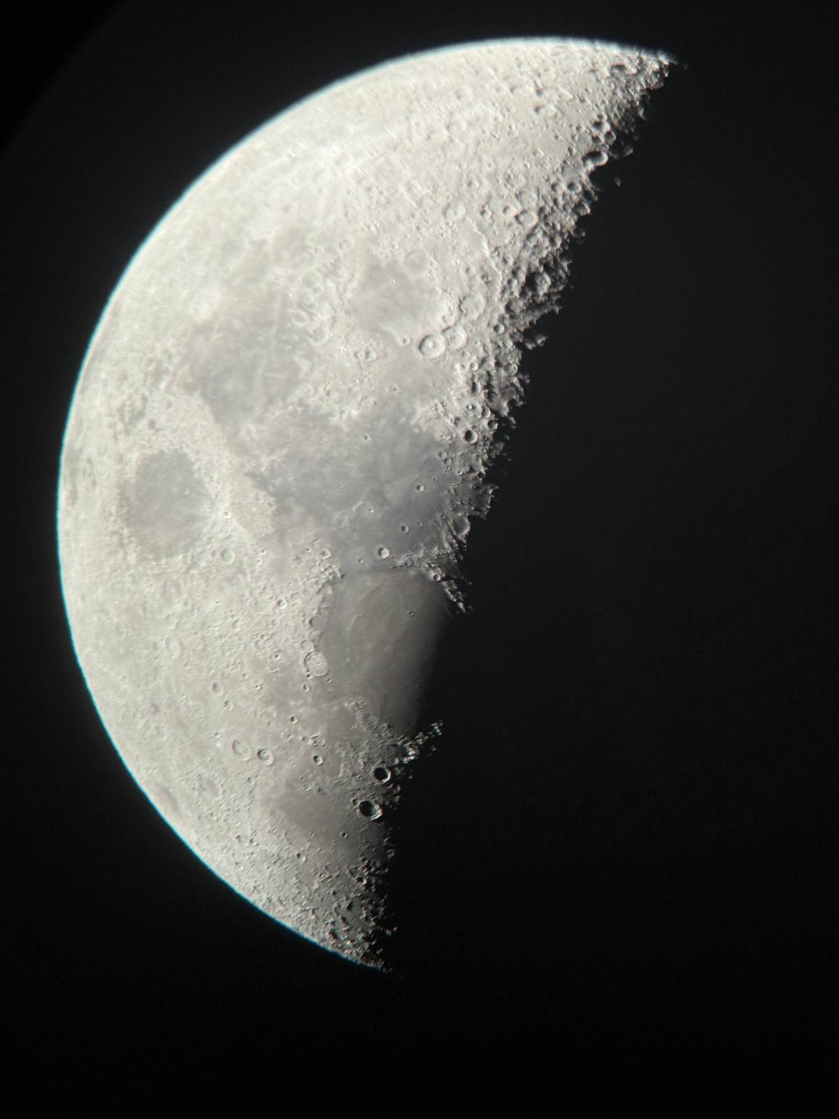 The half Moon with its craters through a telescope