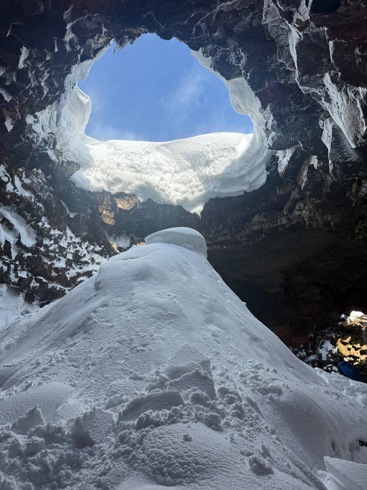 Daylight and snow below a collapsed opening in the roof