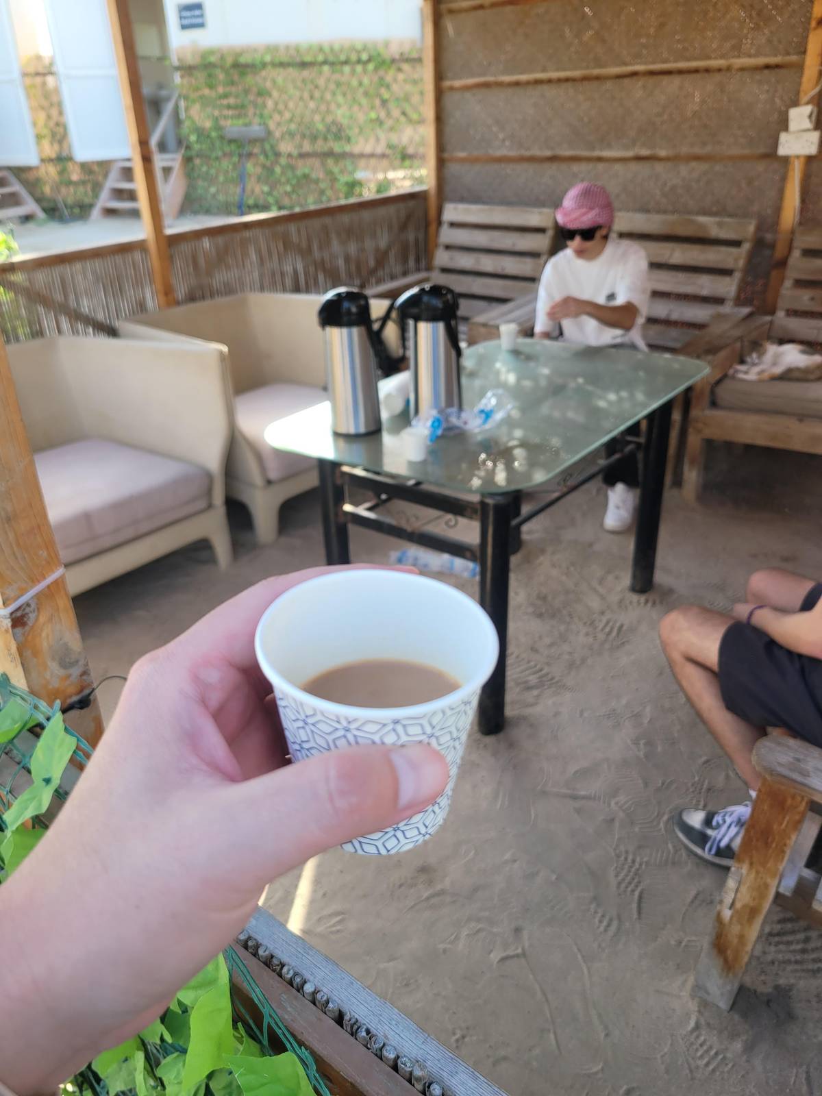 A paper cup of tea at a desert camp
