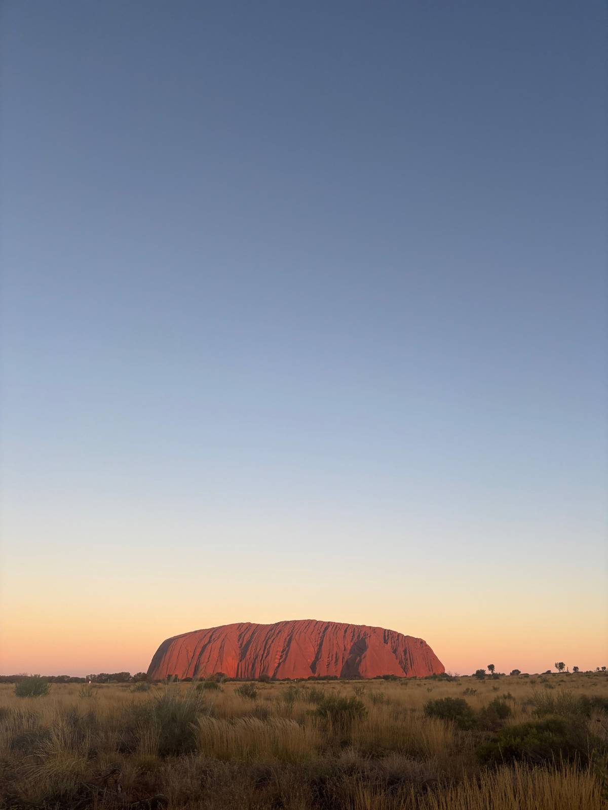 The rock as a dark red line under a fading sky