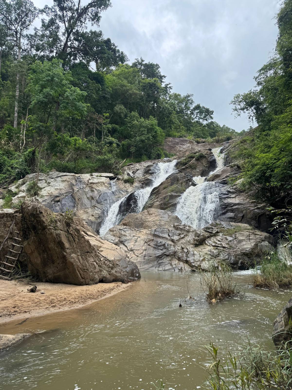 Water spilling over granite steps into a sandy stream pool