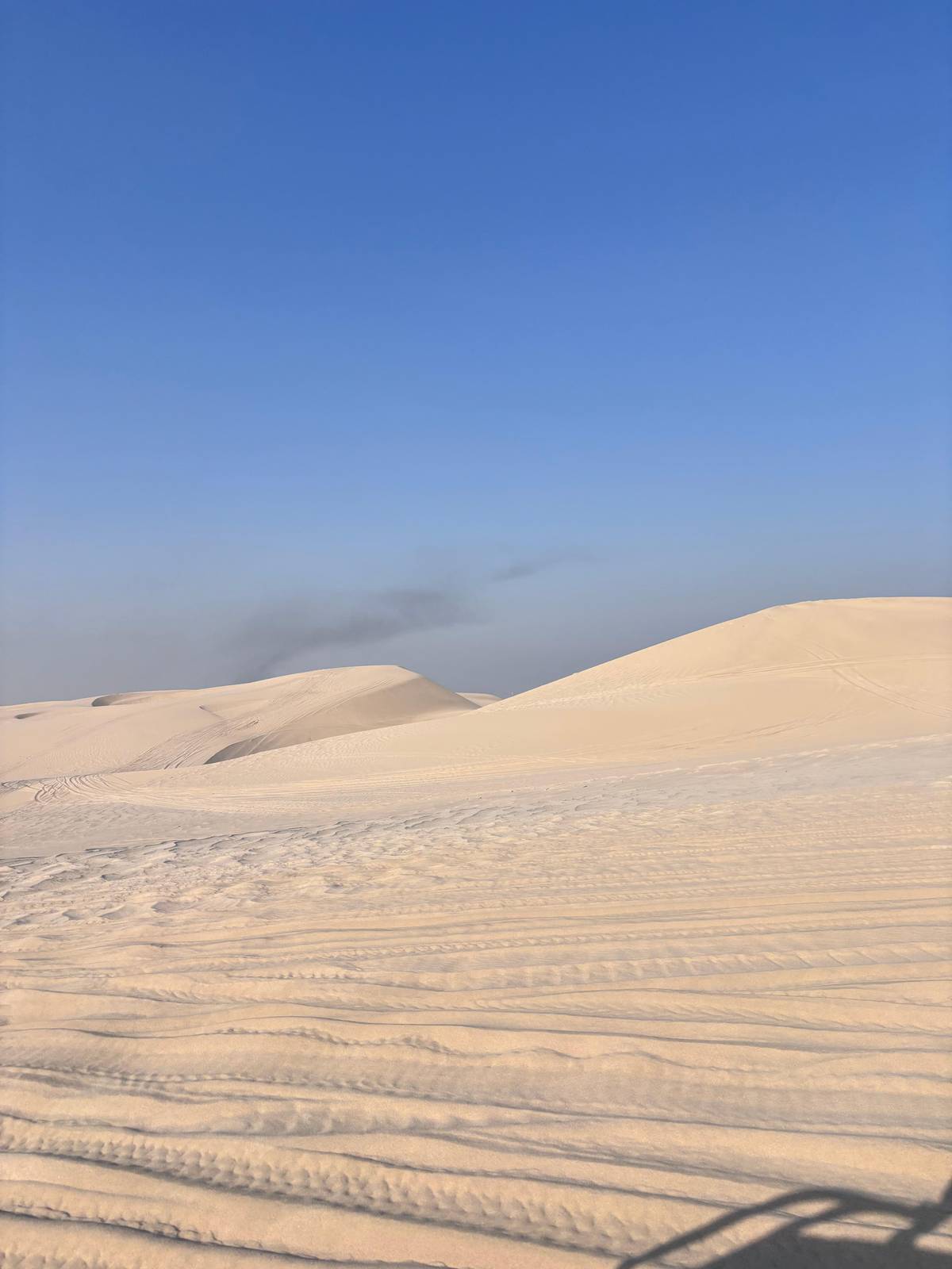 Soft cream dunes under a blue sky