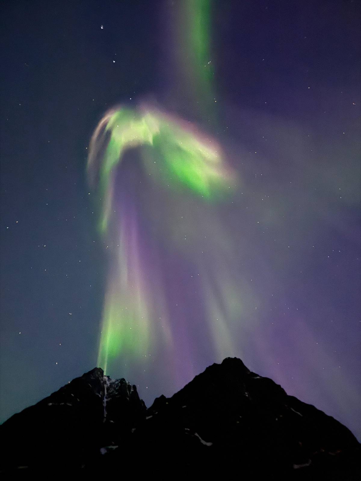 Nordlicht über einem Berggipfel