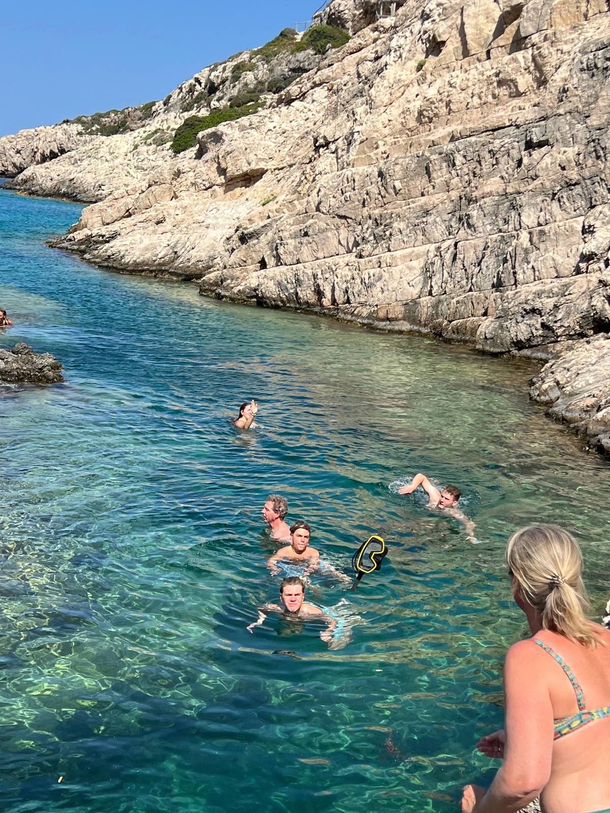 Guests swimming in the clear cove at Korakonisi