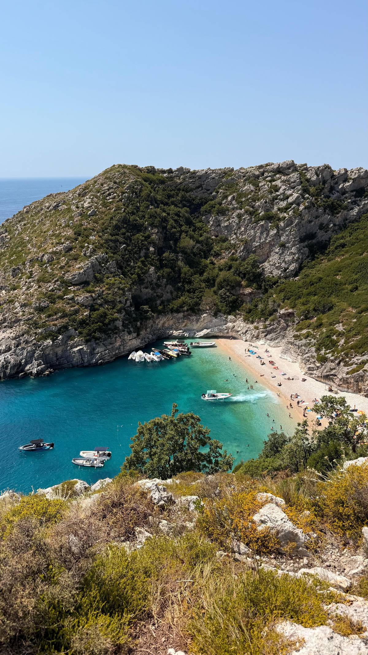 A small bay with boats at anchor, from the slope above