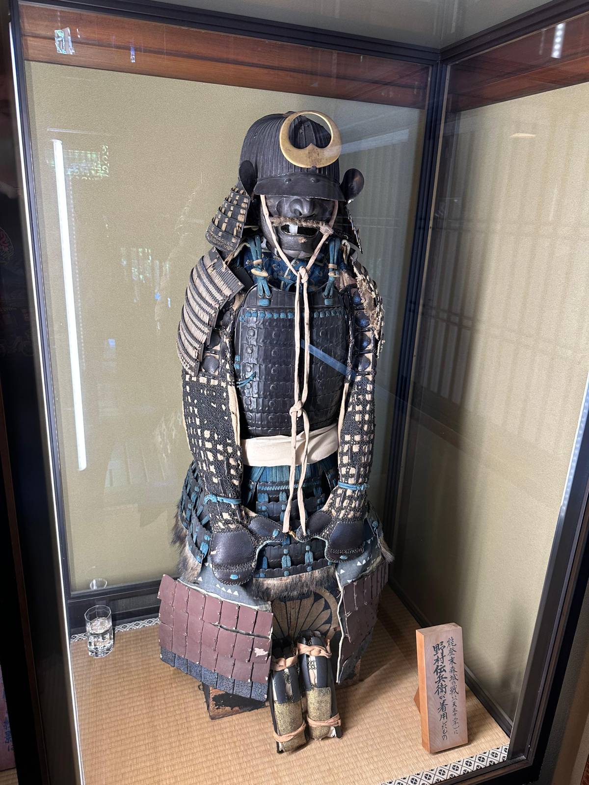 A suit of samurai armor behind glass