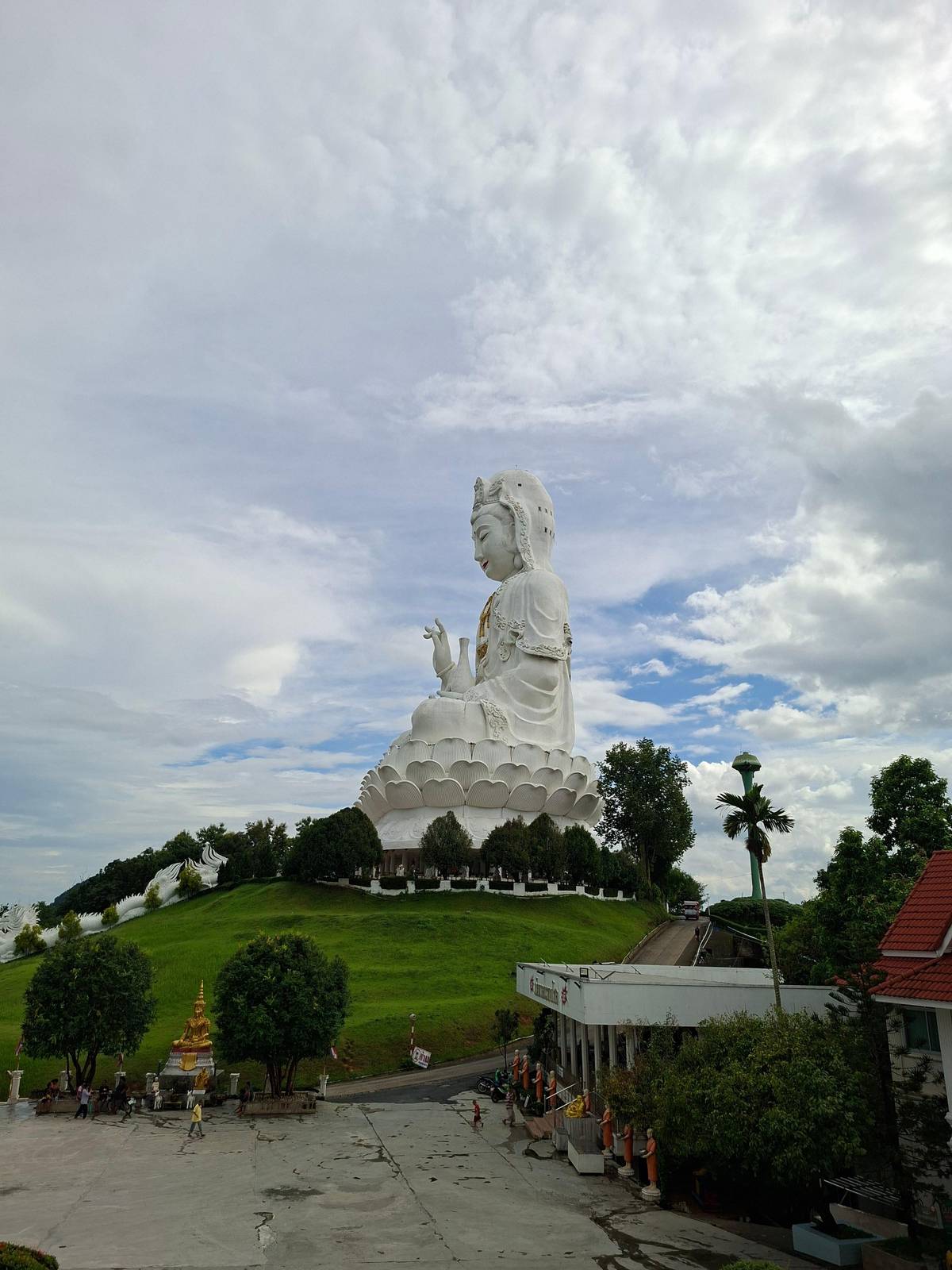 The white Guan Yin statue on its hill above green lawns