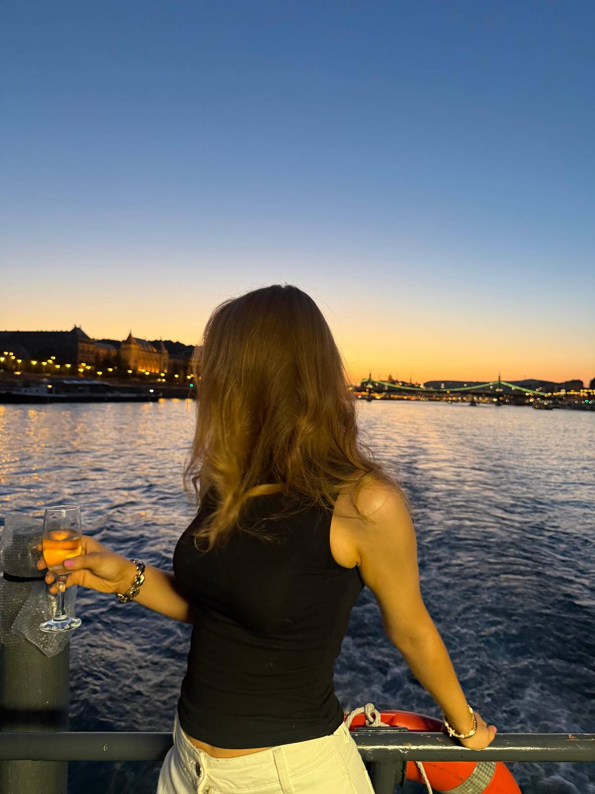 A guest at the rail as the sun goes down over Buda