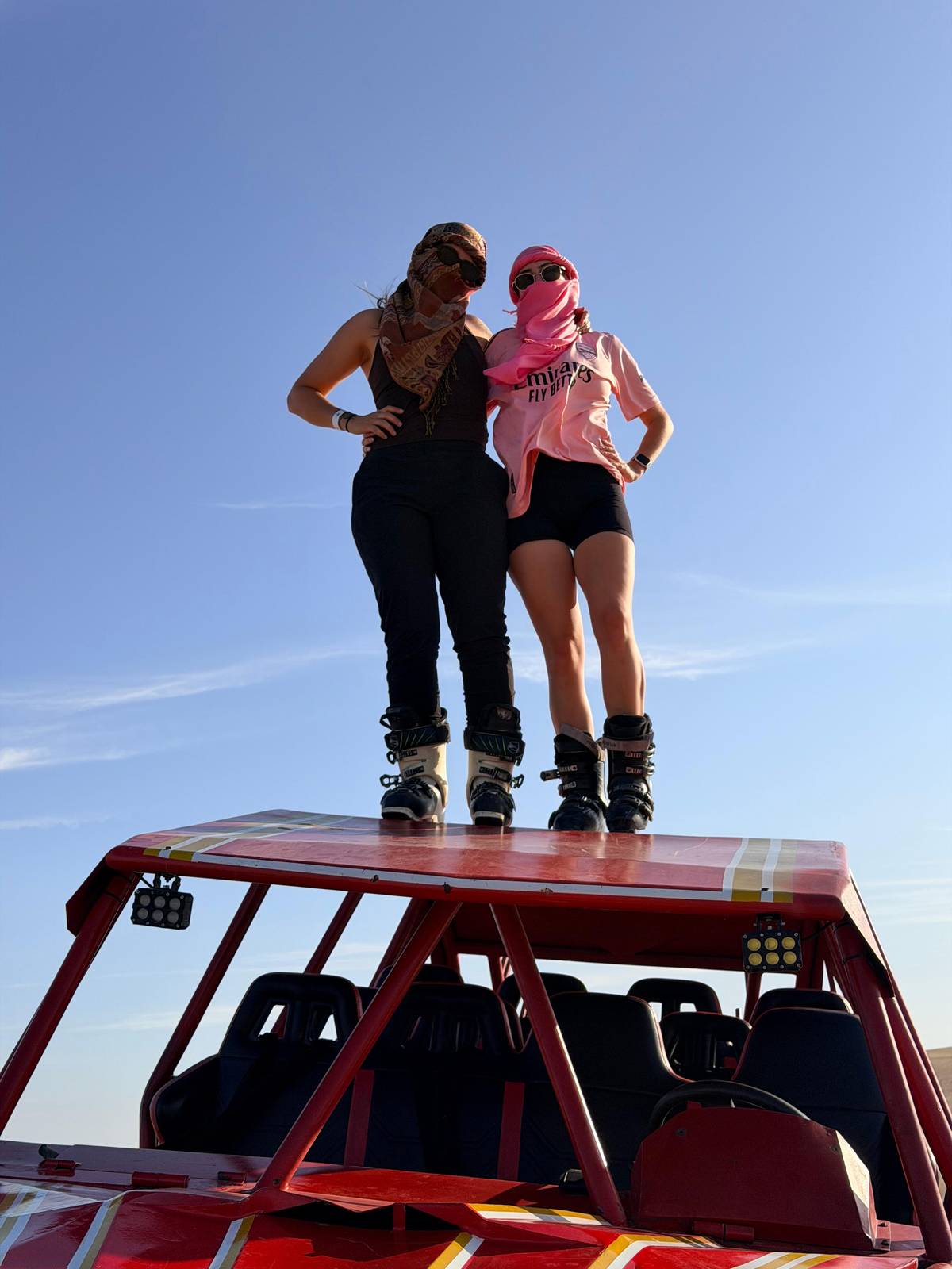 Two riders in boots standing on the roof of a buggy