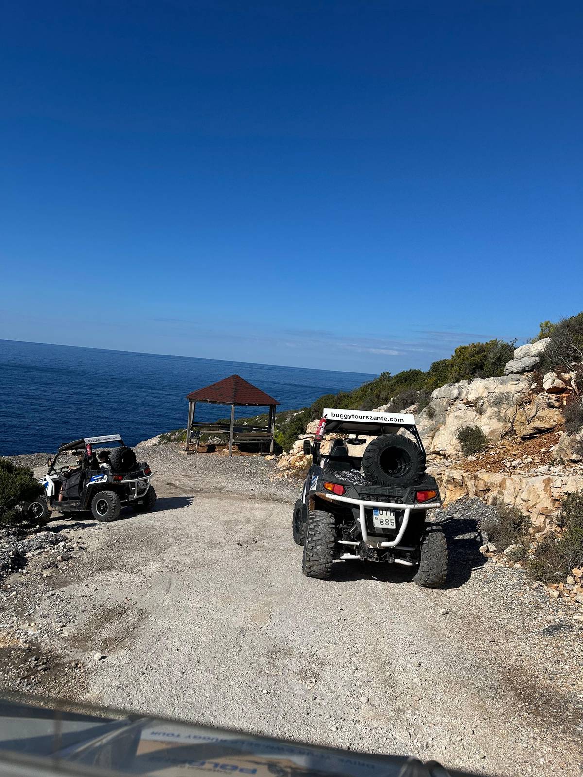 Two buggies on a cliff track above the sea