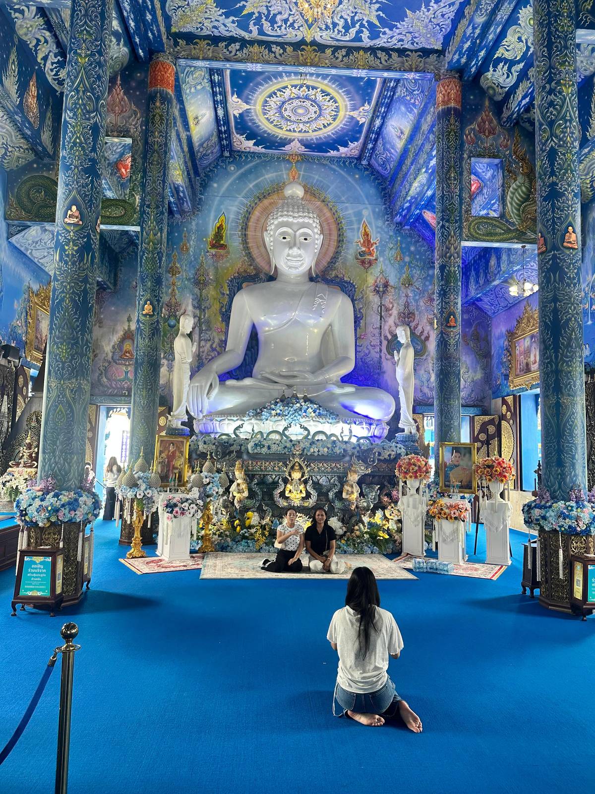 A white Buddha on a deep blue altar inside the Blue Temple