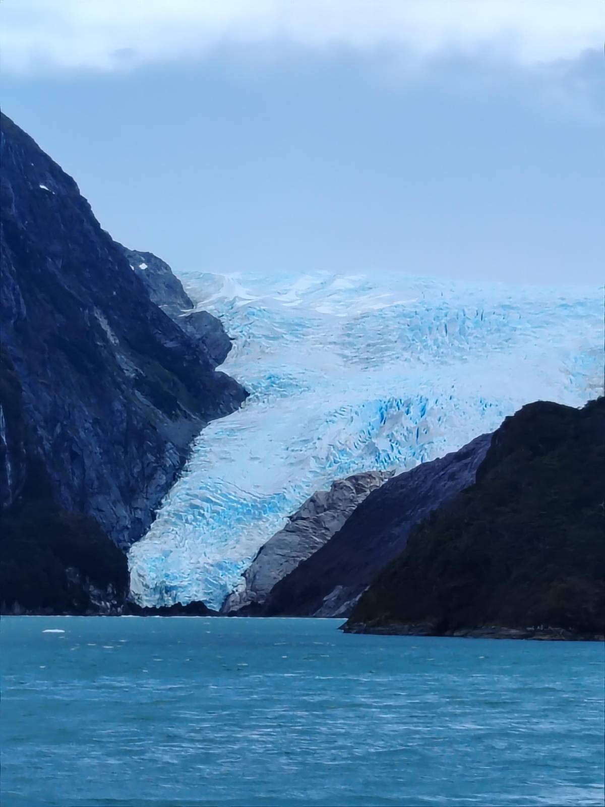 A glacier spilling into the head of a fjord