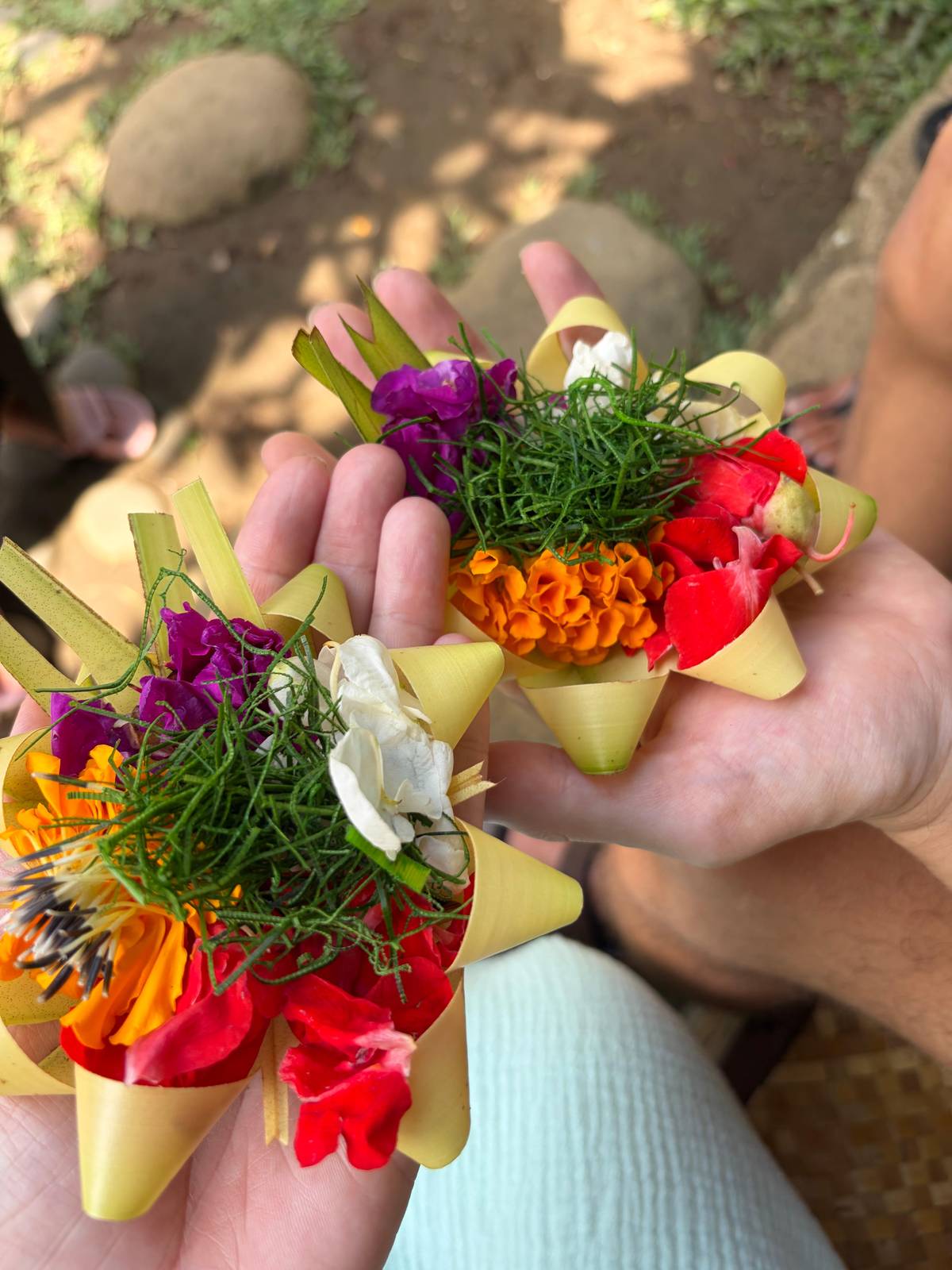 Small woven palm-leaf offerings filled with flowers