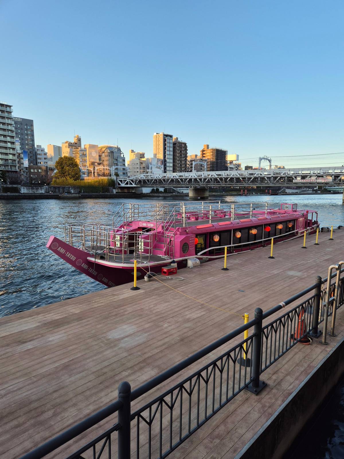 A yakatabune moored at a riverside pier in daylight