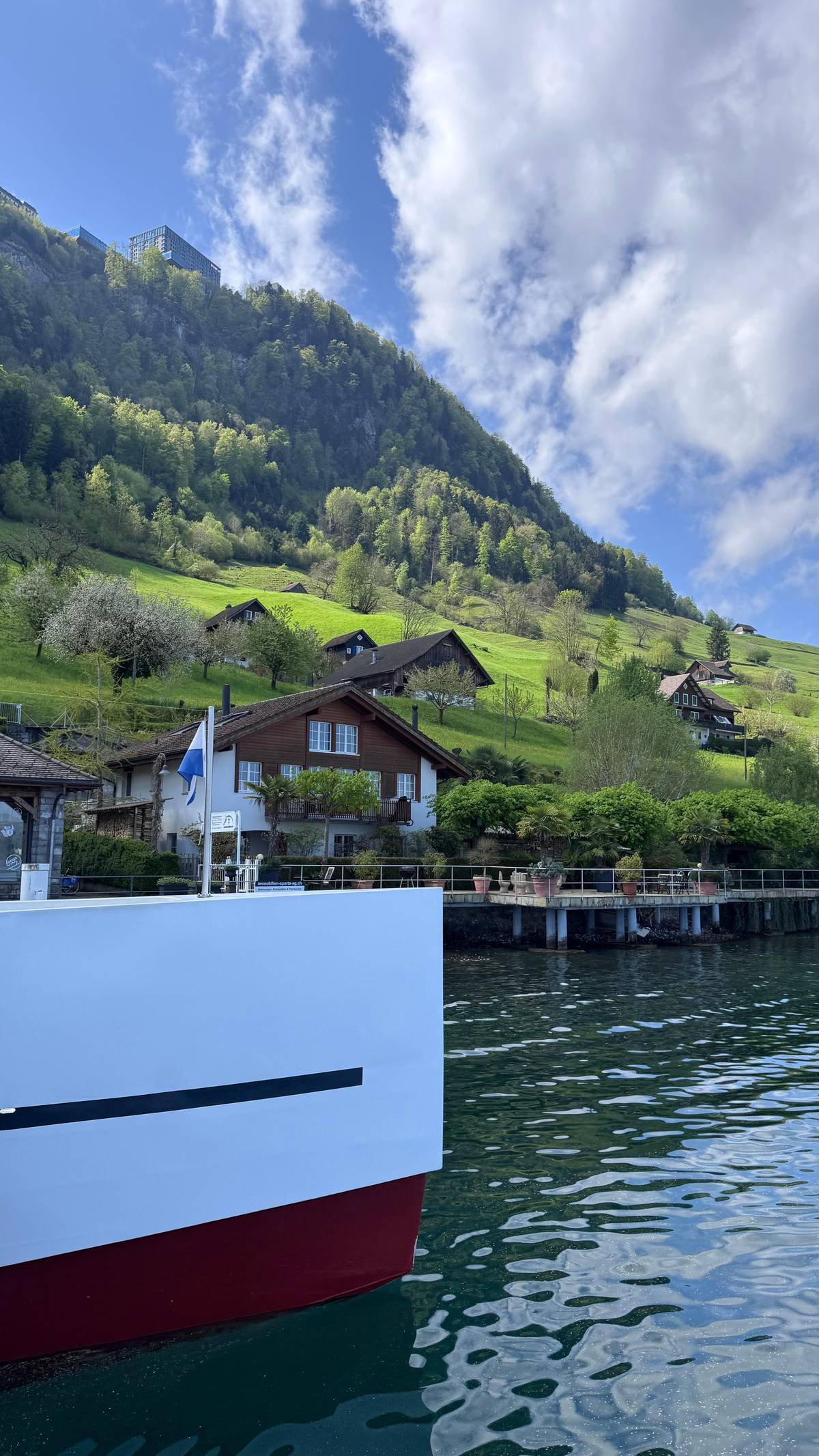A village above the shore seen from the boat