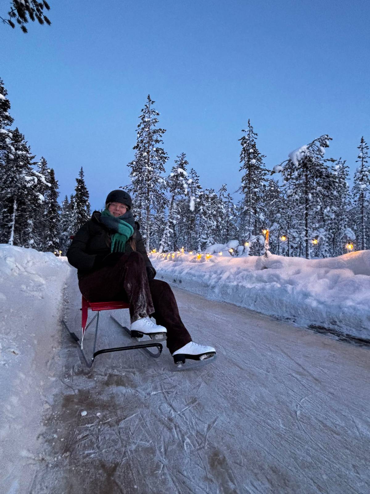 A guest sitting on a kicksled on the ice