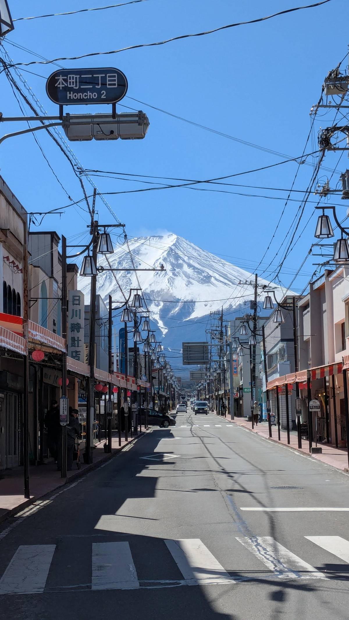 A shopping street running straight towards snowy Fuji