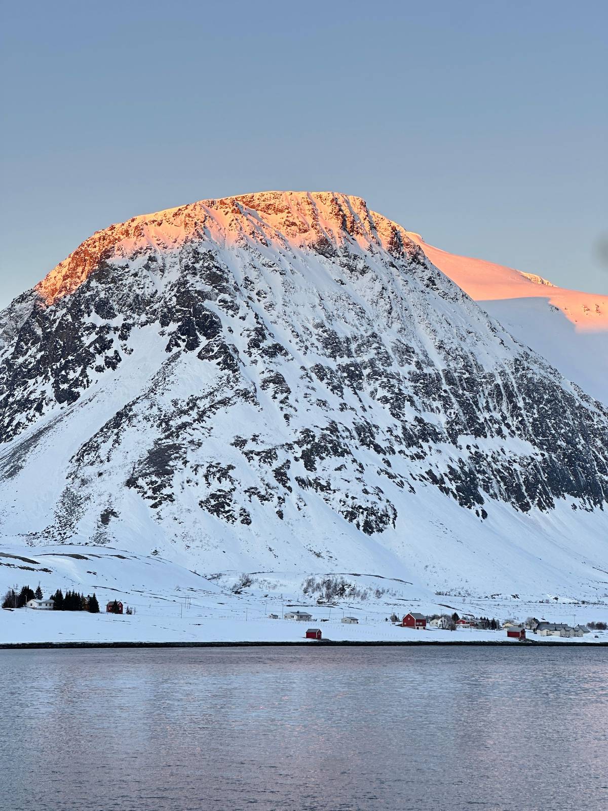 A snow-covered peak by the fjord