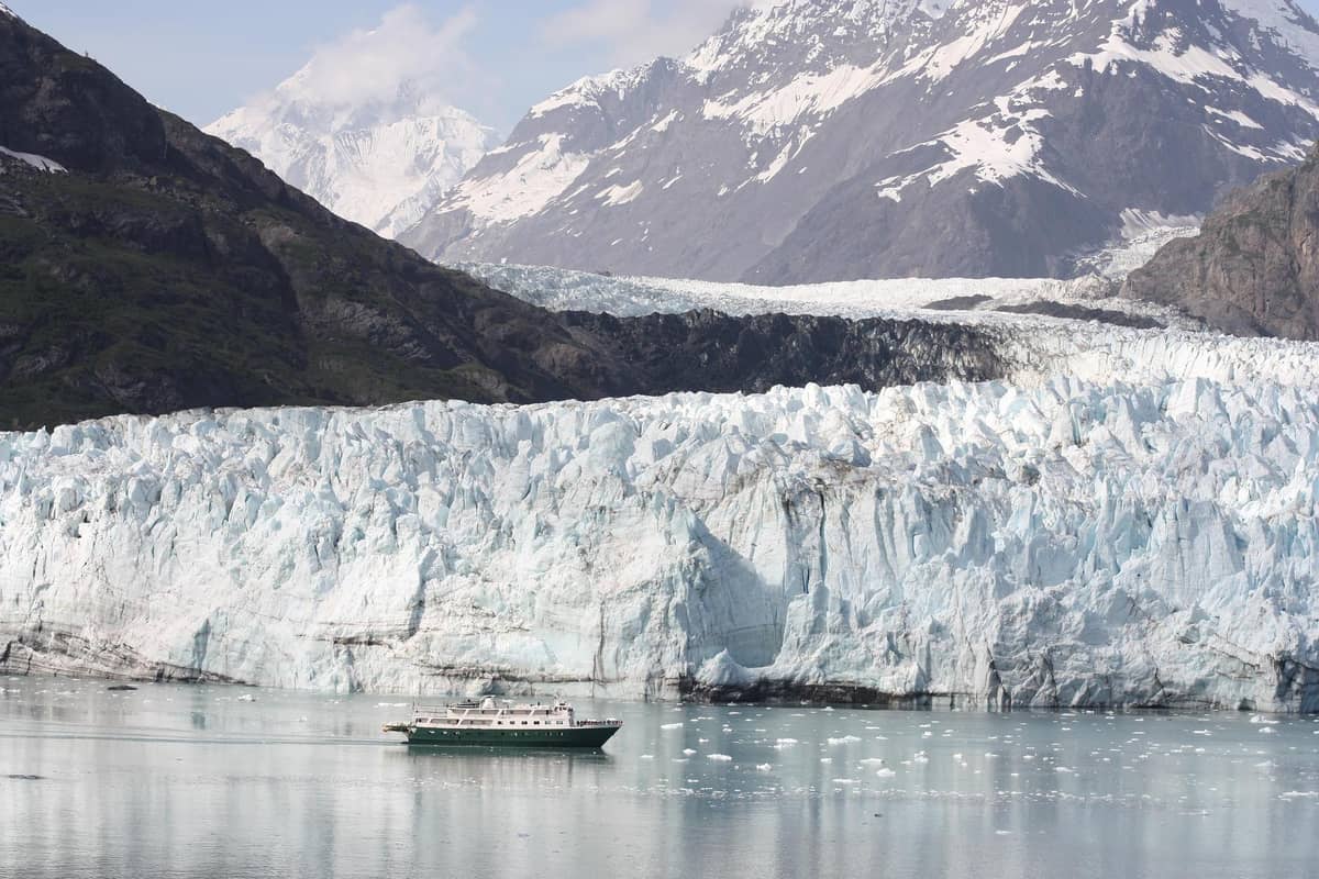 A small boat below a tidewater glacier