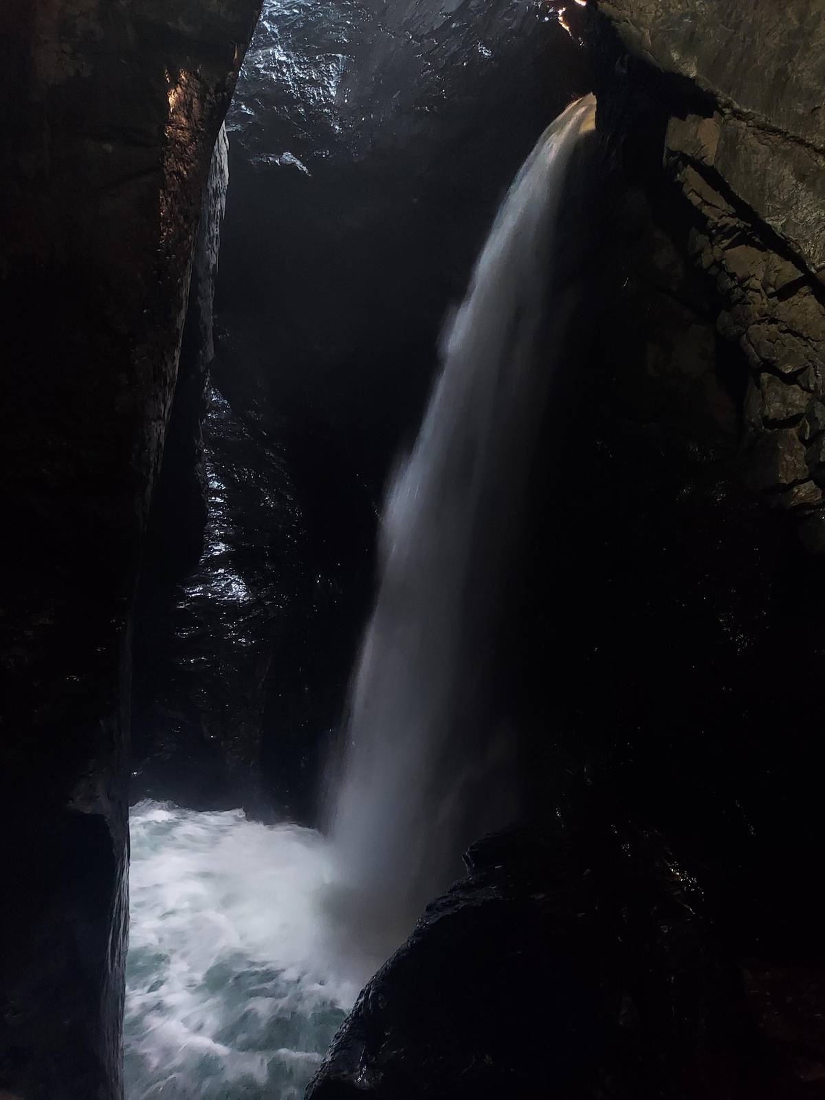 Glacier water pouring through a dark gorge