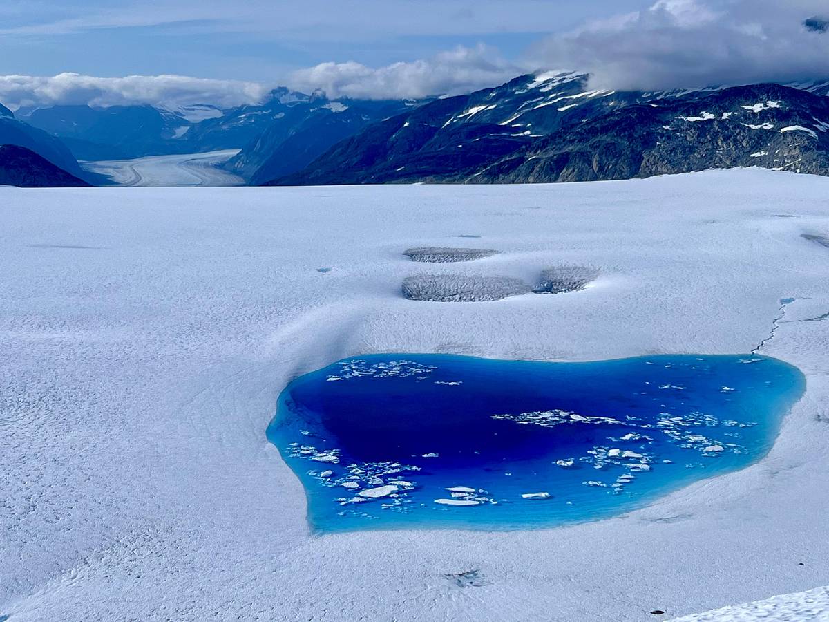 A pool of blue water in the snow