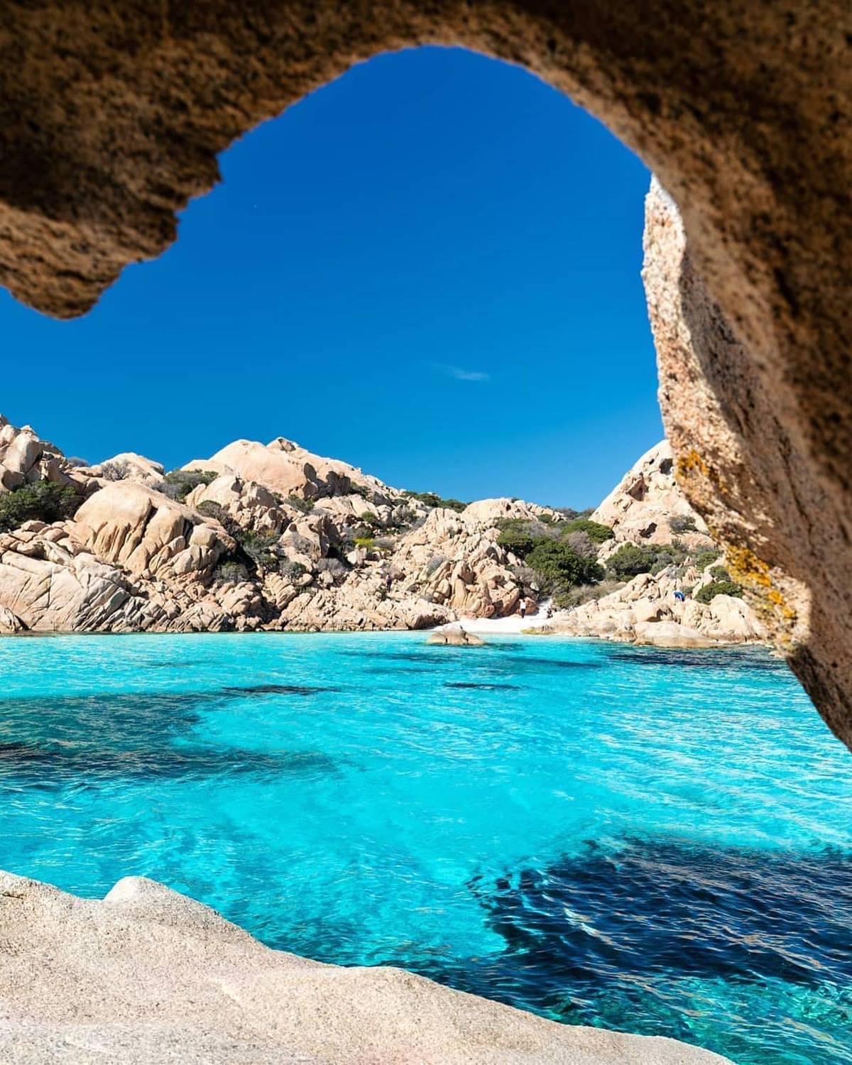 Clear water framed by a rock arch