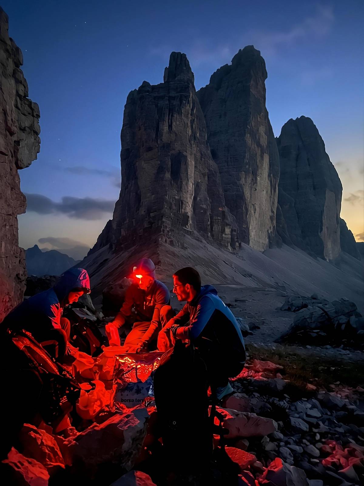 Hikers at night below the peaks