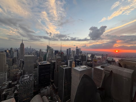 The sun going down over Midtown rooftops, the sky burning orange behind the water towers