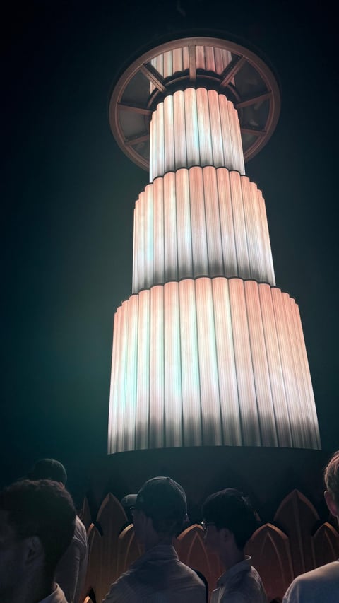 Visitors gathered under the illuminated tiered sculpture on the way up to the observation decks