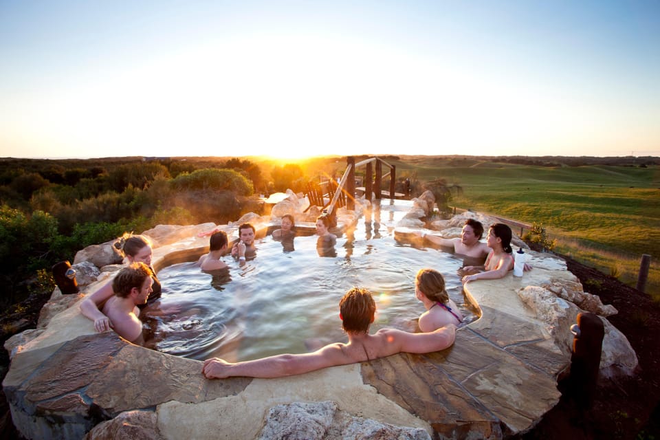 Steam rising from an outdoor thermal pool surrounded by trees