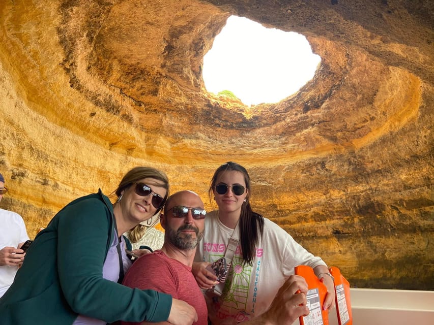 Gäste posieren an Bord eines Bootes in der Benagil-Höhle