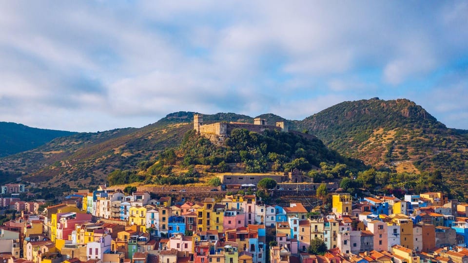 A winding coastal road above dark blue sea and rugged cliffs in western Sardinia
