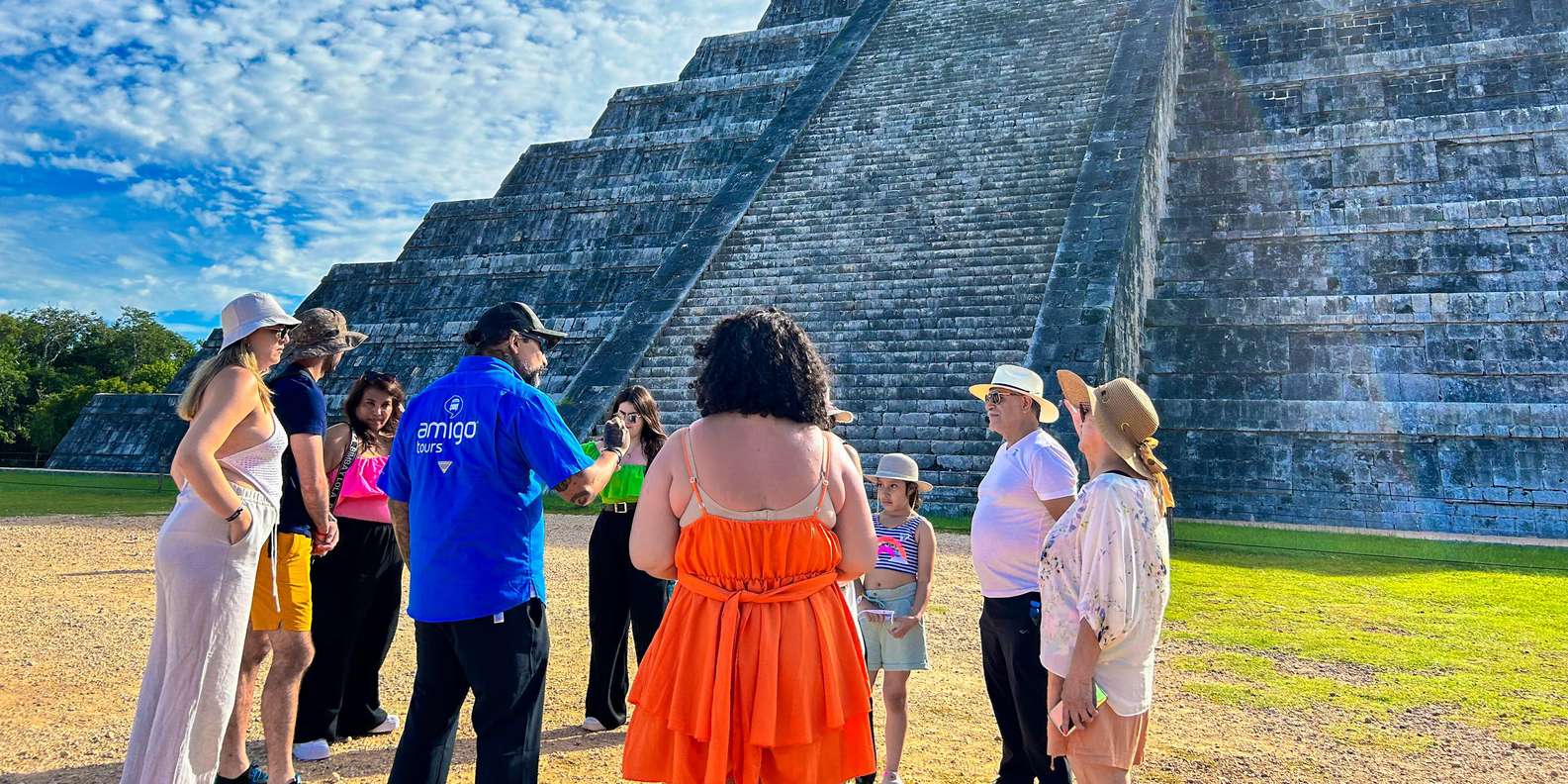 The El Castillo pyramid at Chichen Itza with visitors on the grass below