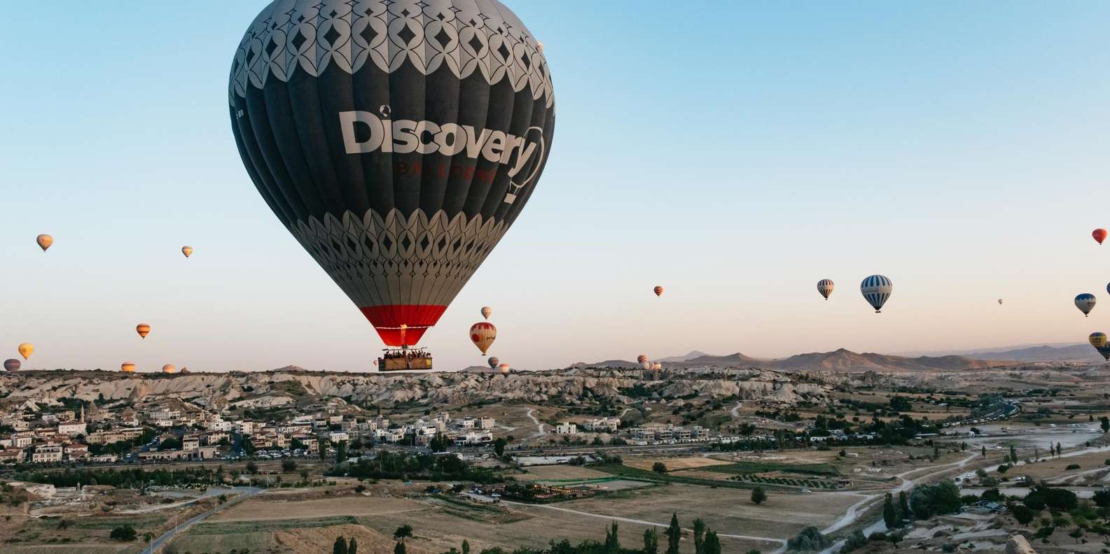 A Cappadocia hot air balloon pilot checking instruments and supervising pre-flight inflation — SHGM-licenced pilots require a minimum 600 flight hours to operate commercially in Cappadocia