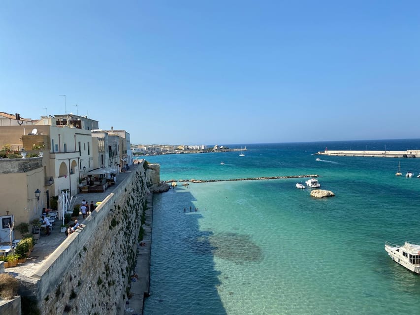 Compact cars parked beside honey-coloured stone buildings on a quiet Lecce street