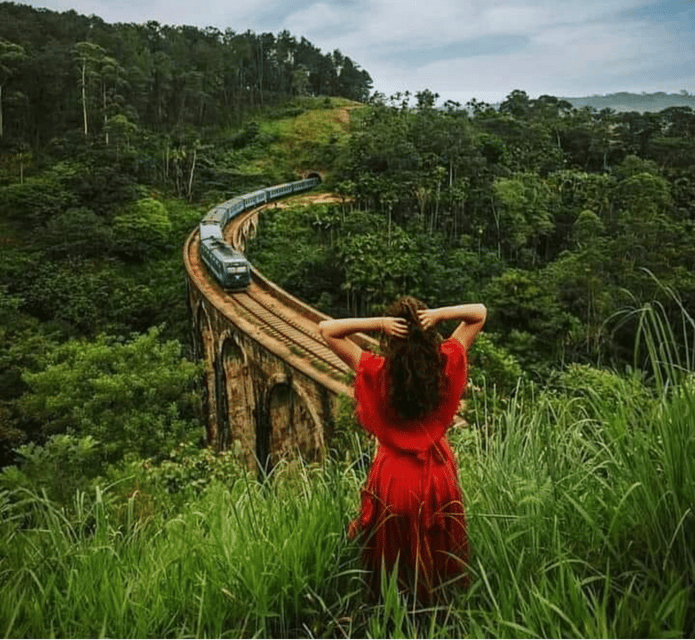 A red tuk-tuk on a narrow road between green hills near Ella