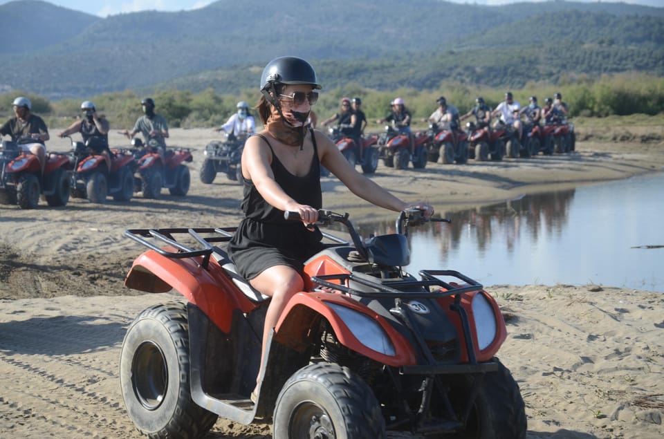 A rider steering a quad along a sandy track near Pamucak Beach
