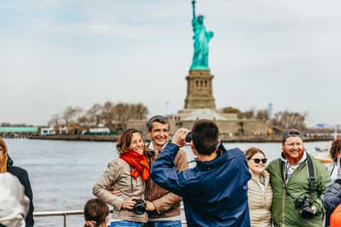 Sightseeing boat passing the Statue of Liberty for photos