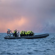 Lancha semirrígida de avistamiento de ballenas en un fiordo ártico nevado cerca de Alta
