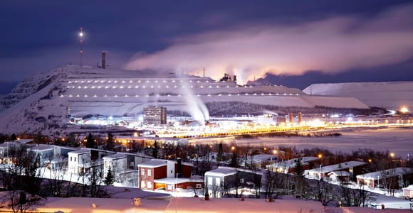 Kiruna at night with the illuminated mine mountain Kiirunavaara behind snowy houses