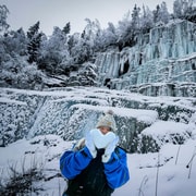 Senderistas delante de una cascada helada azulada en el cañón de Korouoma, en la Laponia finlandesa